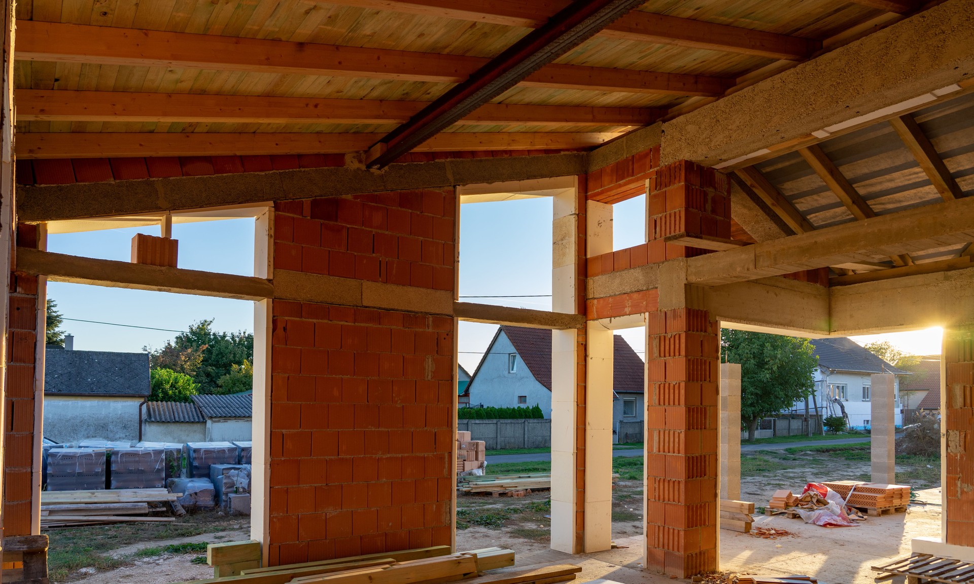 house under constraction with modern brick walls and holes for doors and windows .